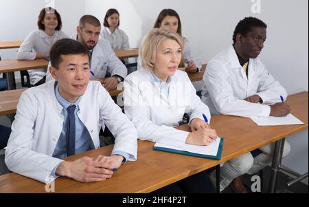 People in white coats in boardroom Stock Photo