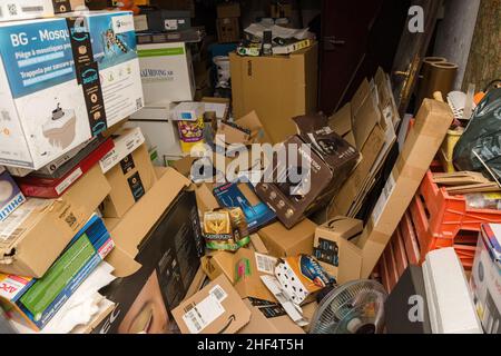 Frankfurt, Germany - Dec 10, 2021: Garage mess with multiple cardboard packages after unboxing thousands of items from amazon and other big retailers Stock Photo