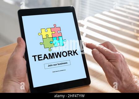 Tablet screen displaying a teamwork concept Stock Photo