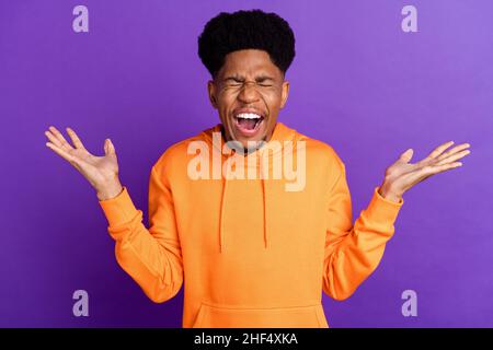 Photo of angry young afro american man bad mood scream hold hands negative isolated on purple color background Stock Photo