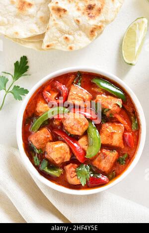 Thai style red chicken curry with vegetables in bowl over light background. Top view, flat lay Stock Photo
