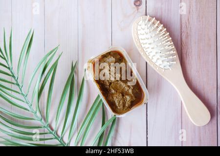 The wooden bowl with rehydrated henna on table Stock Photo