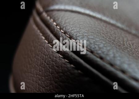 beautiful smooth seam in the leather upholstery of the car seat close-up. Stock Photo