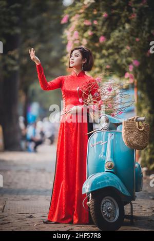 Ho Chi Minh City, Vietnam: Portrait of a brilliant Vietnamese girl in a red ao dai to welcome the Vietnamese traditional New Year Stock Photo