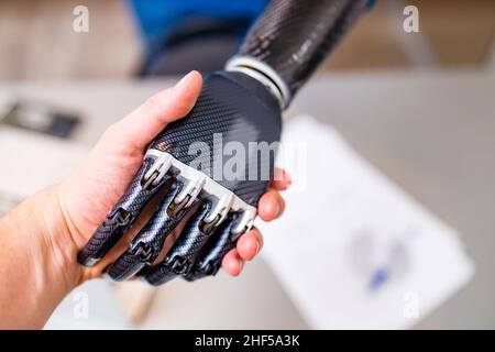 Handshake between hand of human and robot hand isolated on office background Stock Photo