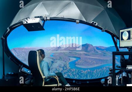 Perm, Russia - January 13, 2022: woman watching educational fulldome movie, projected on a small dome Stock Photo
