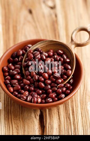 Raw Adzuki Beans or Red Mung Beans in a Bowl and Spoon on Wooden Table Stock Photo