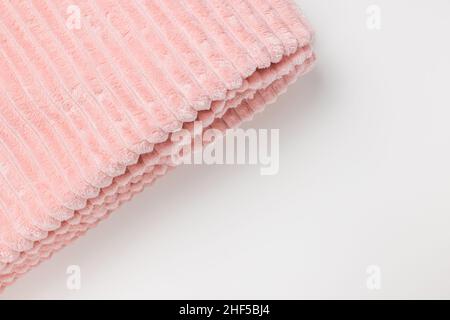 New folded soft pastel pink fleece throw fabric with lines on white background. Top view, closeup, copy space Stock Photo