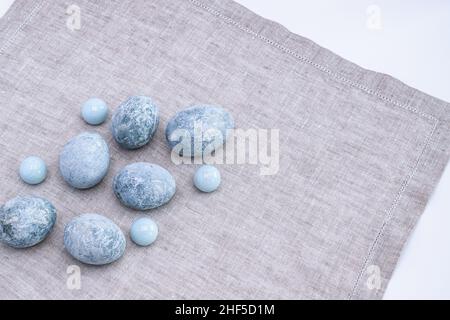 Marble Easter eggs on a gray linen napkin. Easter greeting card. Horizontal photo. Stock Photo