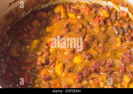 beans with vegetables and yellow sauce in an aluminum pan Stock Photo