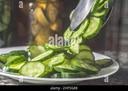 Cucumber pickles on a white plate with dark background and copy space. Stock Photo