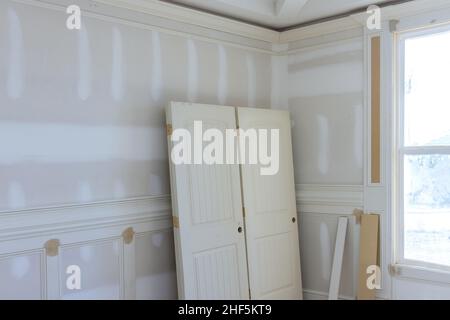 View of on stacker wooden material door molding trim with new house of under construction Stock Photo