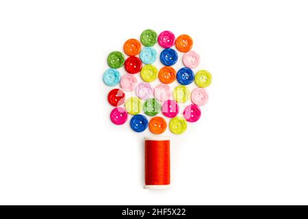 Colored buttons and a thread spool in a tree shape on a white background Stock Photo