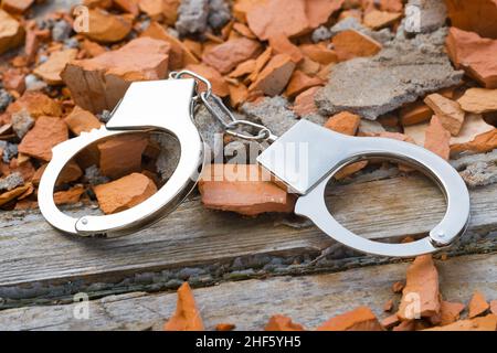 silver handcuffs lie on the ground. High quality photo Stock Photo