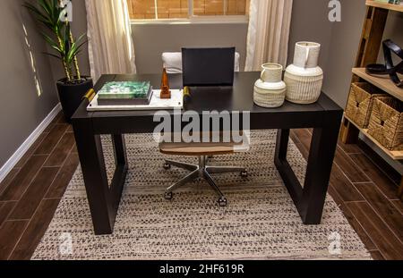 Home Office Desk With Small Laptop Computer And Decorative Items Stock Photo