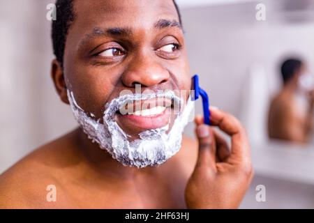hispanic man put on foam on beard perfume lotion or skin care cream for sensitive skin Stock Photo