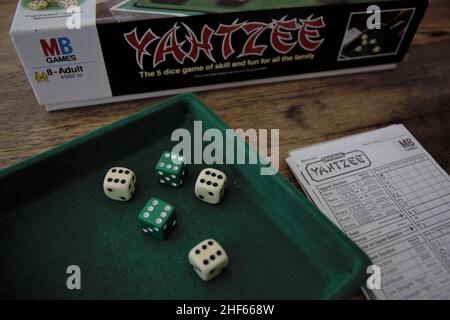 Yahtzee is a fun game for all the family. A dice game made by Milton Bradley (now owned by Hasbro), players roll the dice three times and log scores o Stock Photo