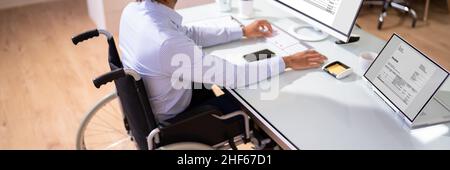 African Accountant With Disability Working On Computer In Wheelchair Stock Photo