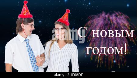 Smiling caucasian couple with party hats celebrating russian orthodox new year over fireworks Stock Photo