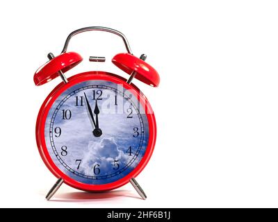 Red alarm clock with clouds on the clock face against a white background Stock Photo