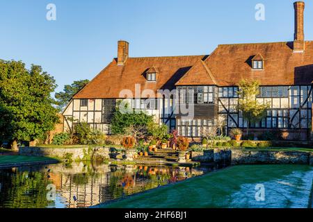 Rear view of the exterior of the iconic Laboratory Building and reflections in the Jellicoe Canal, RHS Garden, Wisley, Surrey in winter on a sunny day Stock Photo