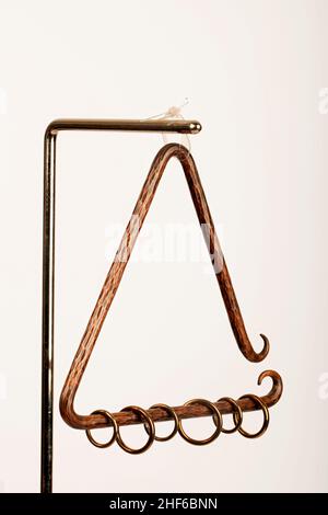 Hand hammered bronze triangle with rings to create an original buzzing sound.  Baroque, Renaissance percussion instrument. Stock Photo