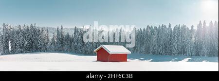 snow-covered red hut in a snowy winter landscape