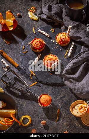 Homemade orange ice cream on a dark background with Ice cream spoon from stainless steel, flat lay, top view Stock Photo