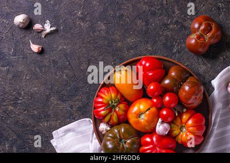 The harvest of assorted tomatoes. Colorful organic tomatoes on a large dish. Tomatoes different varieties. Top view Stock Photo