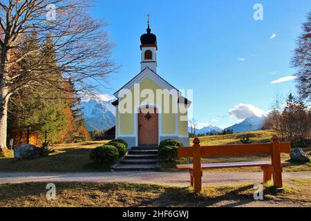 autumn landscape with chapel Maria Rast on the Buckelwiesen,  bench,  beech,  Krün,  Werdenfelser Land,  Upper Bavaria,  Bavaria,  Germany Stock Photo