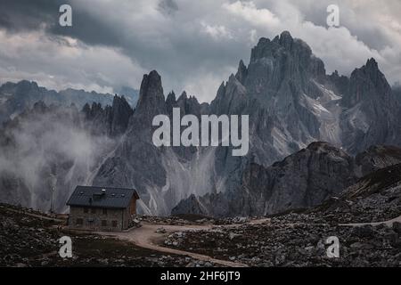 Mountain hut near the Three Peaks and in the background the Cadini di Misurina. Stock Photo