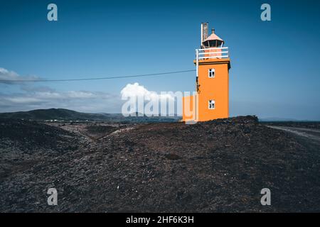 Lighthouse with active volcano in the background,  Hópsnesviti,  Iceland Stock Photo