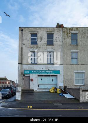 Run down building with derelict Chinese Take Away shop at ground level, Esplanade, Burnham-on-Sea, Somerset, England Stock Photo