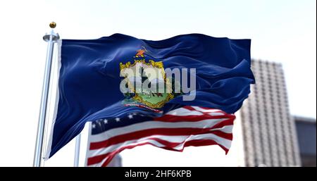 the flag of the US state of Vermont waving in the wind with the American flag blurred in the background. Vermont was admitted to the Union on March 4, Stock Photo