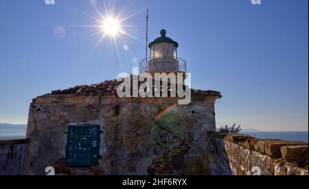 Greece,  Greek Islands,  Ionian Islands,  Corfu,  Corfu Town,  old fortress,  lighthouse on top of the fortress,  backlit photo,  wreath of sun behind lighthouse roof,  blue sky,  rainbow reflections Stock Photo