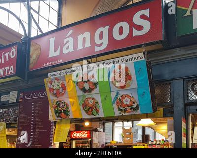 Budapest, Hungary - 13 March 2018: Langos market stall, inside the popular Central Market Hall. Lángos, a Hungarian food speciality. Deep fried dough Stock Photo