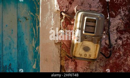 Greece,  Greek Islands,  Ionian Islands,  Corfu,  west coast,  Pentati,  house wall,  front door blue on the left in the picture,  electricity meter on the right on the pink wall Stock Photo