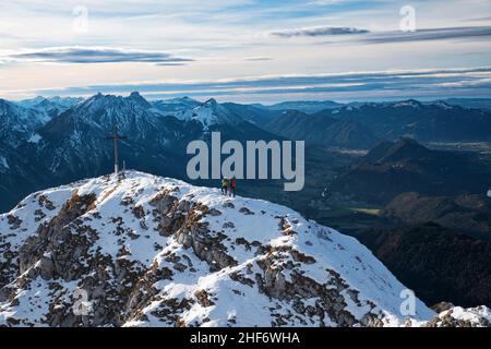Two mountaineers reach the early winter snow-covered summit of the Säuling on a sunny autumn day. Ammergau and Allgäu Alps,  Tyrol,  Austria,  Bavaria,  Germany,  Europe Stock Photo