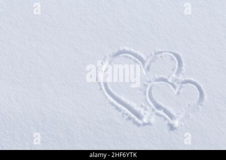 white snowy background with two hearts drawn on it Stock Photo