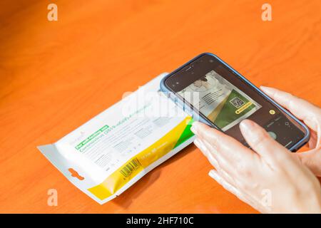 Seville. Spain. 28 December, 2021. Close-up of a smartphone scanning the QR code of a Covid19 antigen self-test kit to obtain information on the proce Stock Photo