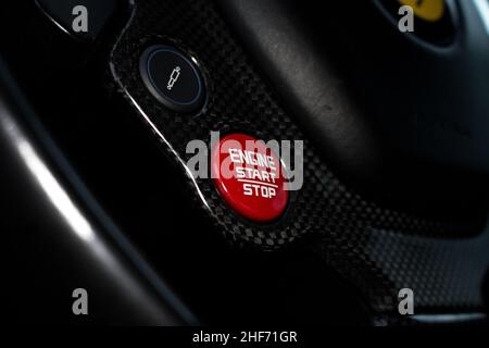 A 2015 Ferrari 488 GTB Red Engine Start Stop Button With Carbon Fibre Steering Wheel Surround On The Multi Function Carbon Fibre Steering Wheel Stock Photo