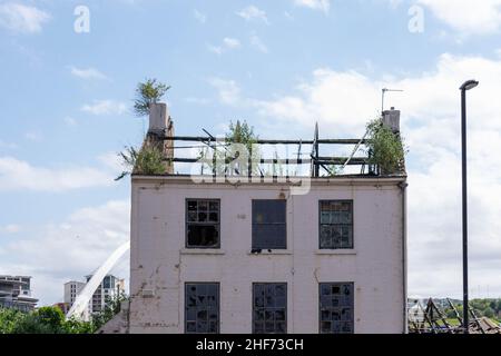 Newcastle, UK - 7th July 2019: An old derelict building in Newcastle, just behind the modern Sage Gateshead structure. Old v new. The empty building i Stock Photo