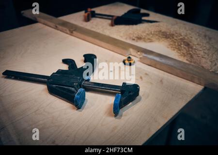 Carpenter clamps lie on workbench Stock Photo
