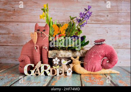 Pretty arrangement of different spring flowers with decoration on a wooden table. Stock Photo