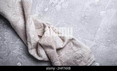 Top view of single folded linen serviette on grey concrete background Stock Photo