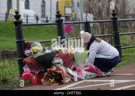 RETRANSMITTED CORRECTING SPELLING OF ASHLING A woman lays flowers with other floral tributes left near to the Grand Canal in Tullamore, County Offaly, where Aisling Murphy was murdered on Wednesday evening. Ashling died after being attacked while she was jogging along the canal bank at Cappincur at around 4pm on Wednesday. Picture date: Friday January 14, 2022. See PA story IRISH Death. Photo credit should read: Damien Eagers/PA Wire Stock Photo