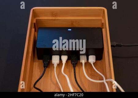 Various cables hang on a docking station for USB cables. Stock Photo