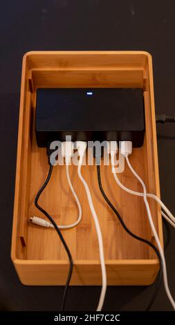 Various cables hang on a docking station for USB cables. Stock Photo