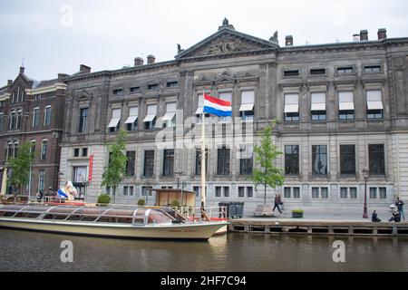 Amsterdam, Holland, The Netherlands - 6th May 2019: The exterior of a traditional building in Amsterdam on the canal front with a floating house boat