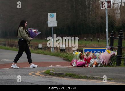 RETRANSMITTED CORRECTING SPELLING OF ASHLING A woman carries flowers to lay with other floral tributes left near to the Grand Canal in Tullamore, County Offaly, where Ashling Murphy was murdered on Wednesday evening. Ashling died after being attacked while she was jogging along the canal bank at Cappincur at around 4pm on Wednesday. Picture date: Friday January 14, 2022. Stock Photo